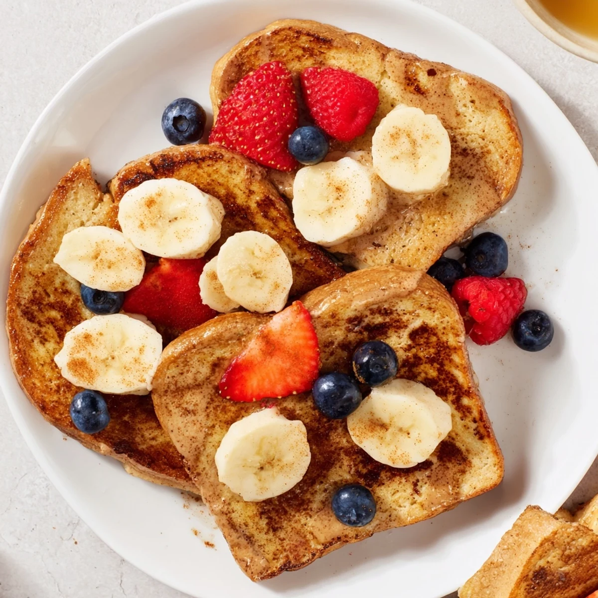 Fluffy Protein French Toast, with a custardy interior and crispy edges, ready to serve with maple syrup.
