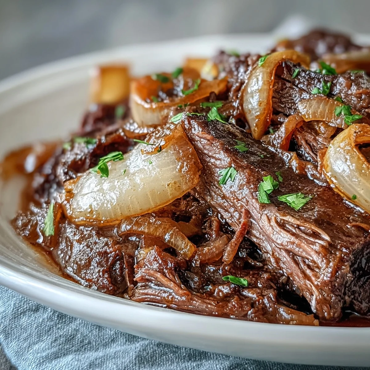 Fork-tender Savory Crock Pot French Onion Pot Roast topped with caramelized onions and thyme-infused red wine jus.