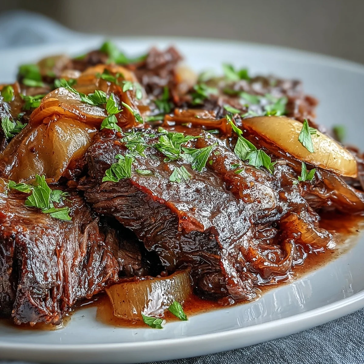 Slices of Savory Crock Pot French Onion Pot Roast served over mashed potatoes with fresh parsley garnish.