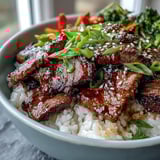 Tender beef slices glazed in sweet and savory teriyaki, garnished with sesame seeds and scallions.