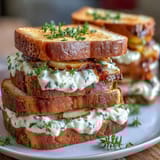 Elegant Mothers Day tea party sandwiches with lemon butter and cucumber, arranged on a tiered platter for a festive brunch.