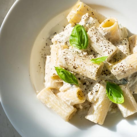 A close-up of creamy cottage cheese pasta, glistening with sauce and Parmesan cheese, plated.