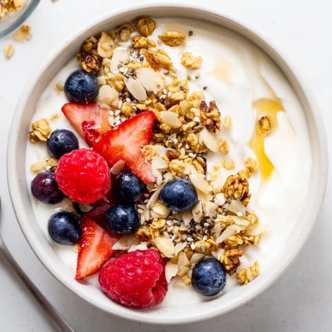 A visually appealing, brightly colored dry yogurt bowl arranged to showcase fresh berries.