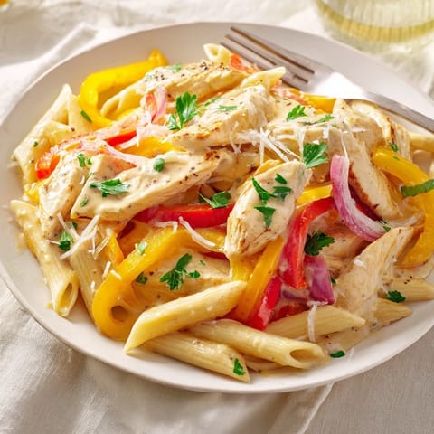 A close-up of Creamy Cajun Chicken Pasta Lite with bell peppers, golden chicken, and penne tossed in a reduced-fat Cajun cream sauce.