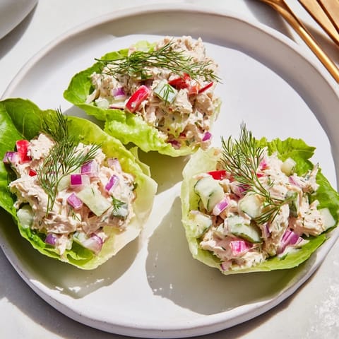 Hearty Dill Pickle Chicken Salad Lettuce Cups served on a rustic wooden board, featuring plump chunks of chicken, chopped pickles, and fresh herbs in each cup, perfect for a light, flavorful lunch.