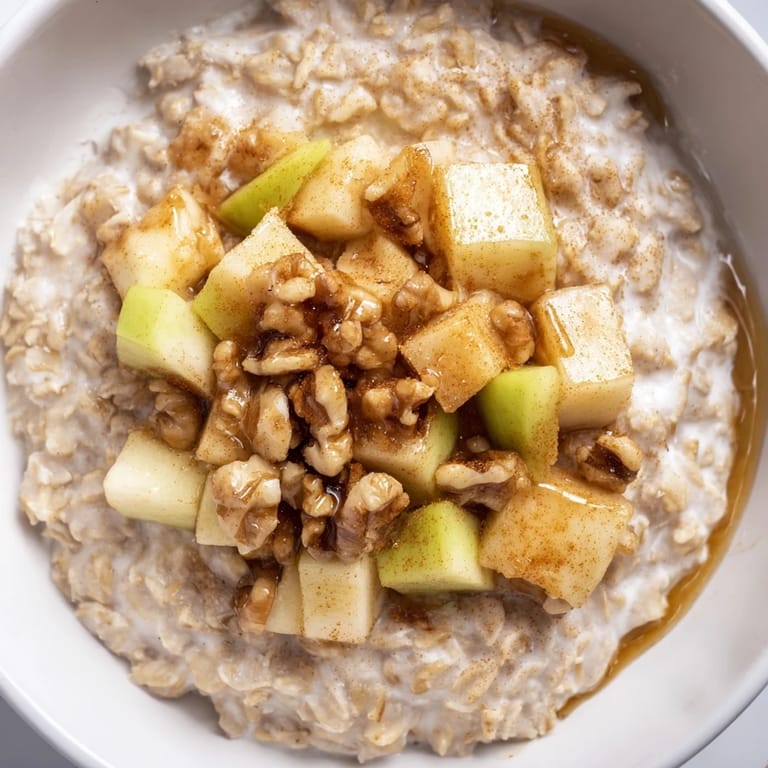 Enjoy a hearty morning: golden Apple Pie Oatmeal Bowl featuring a sweet apple topping, ready to eat.