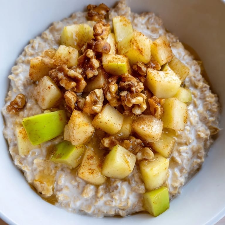 A comforting close-up: creamy Apple Pie Oatmeal Bowl, showcasing the soft oats and diced apple topping.