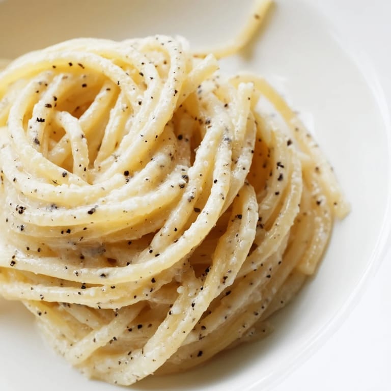 Golden, glossy Lazy Girl Three-Ingredient Pasta, ready to serve with extra grated Parmesan cheese.