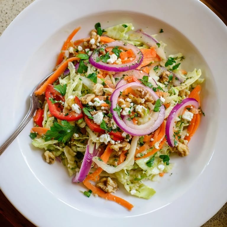 This Cooked and Loved Cabbage Salad is served warm in a white bowl, drizzled with tangy apple cider vinaigrette for a fresh weeknight side.