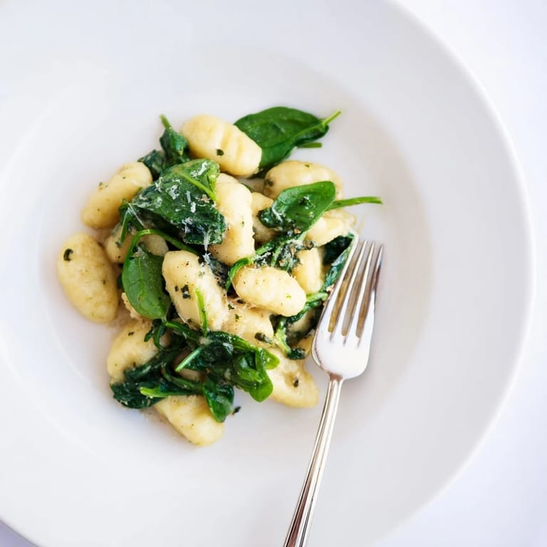 A comforting plate of Creamy Garlic Gnocchi alongside a glass of Pinot Grigio, a perfect vegetarian main dish for dinner.
