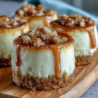 Housewarming Mini Cheesecakes with golden graham cracker crust and smooth cream cheese filling, topped with fresh berries for a festive dessert platter.